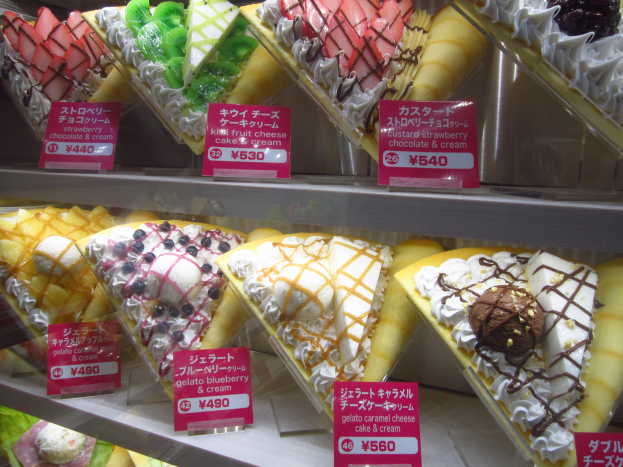 Eine Vitrine voller verschiedener Eissorten, jede mit einem Preisschild beschriftet und nach Farbe, Form und Geschmack sortiert.