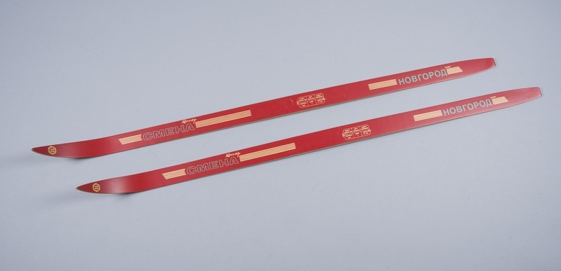 Zwei rote Ski auf einer weißen Fläche gestapelt mit Text, der die Marke oder das Modell angibt.