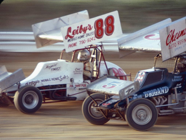 Mehrere Autos fahren auf einer Straße mit einer Sicherheitsbarriere, mit einem unscharfen Hintergrund.