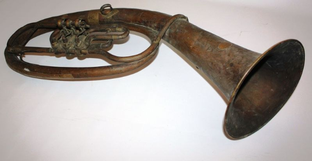 Altes Messinghorn mit glänzendem Finish, gebogenem Hals und aufgeblähtem Schalltrichter, verziert mit kunstvollen Gravuren auf einem weißen Hintergrund.