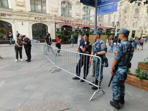 Polizisten in Uniform stehen hinter Barrieren und blicken auf eine Menge, einige halten Waffen, mit Schildern und Gebäuden im Hintergrund während einer Anti-Terror-Operation in Wien, Österreich.