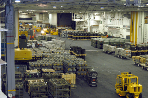 Ein großes Lager voller Numerous Trucks, Container, Menschen, Lichter, Stangen und andere Gegenstände mit einem sichtbaren Rad.