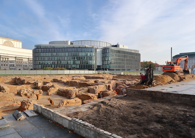 Baustelle in Berlin mit einem großen Gebäude im Bau, umgeben von Fahrzeugen, Arbeitern, Materialien und der Berliner Mauer im Bau.