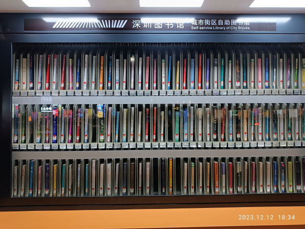 Eine gut beleuchtete Bibliothek mit hohen Bücherregalen voller Bücher, mit einer Tafel mit Text und einem Wasserzeichen unten.