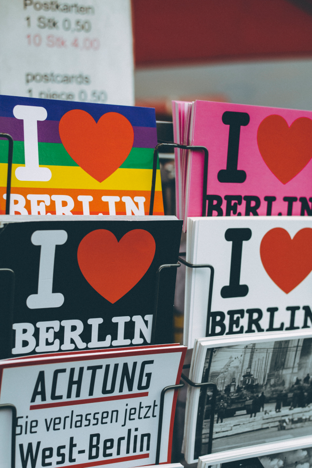 Ein Gestell mit verschiedenen Büchern und Plakaten mit der Aufschrift "Ich liebe Berlin" vor einem sanft unscharfen Hintergrund.