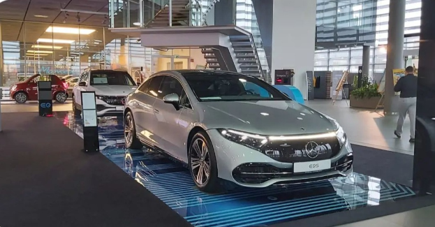 Ein Mercedes-Benz S-Klasse Coupé wird auf der IAA in Frankfurt präsentiert, umgeben von Menschen, einer Glaswand, Treppen und Lichtern.