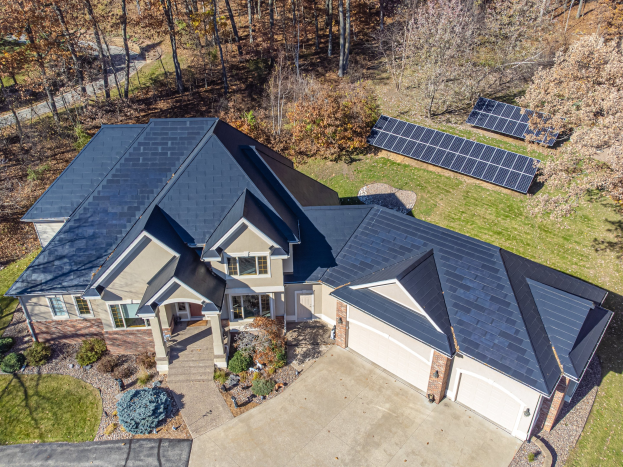 Luftaufnahme eines Hauses mit Solarpaneelen auf dem Dach, umgeben von grünem Gras, Pflanzen und Bäumen in North Carolina.