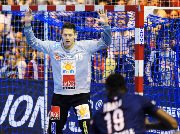 Handballspieler hebt Hände in der Nähe eines Tors bei der Futsal-Weltmeisterschaft 2019, mit Zuschauern und einem Banner im Hintergrund.