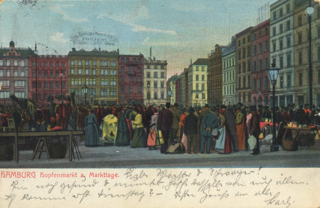 Schwarz-weiß-Postkarte eines belebten Hamburger Marktes mit Menschen, Tischen voller Waren, Straßenlaternen, Schildern und Gebäuden unter einem bewölkten Himmel, mit Text unten.