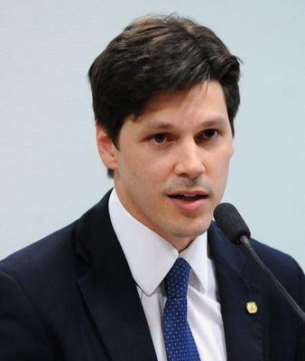 Ein Mann im Anzug spricht in ein Mikrofon an einem Rednerpult, wahrscheinlich um die Genehmigung eines Gesetzes zur Verbot des Internetgebrauchs durch die Regierung zu kommentieren.